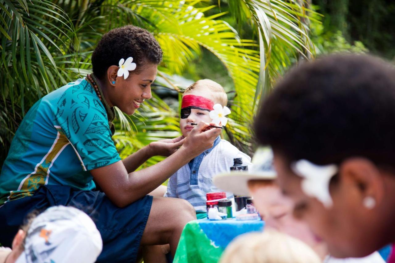 Outrigger Fiji Beach Resort Korotogo Exterior foto A young woman from the Cook Islands applying titi muka to a child's face