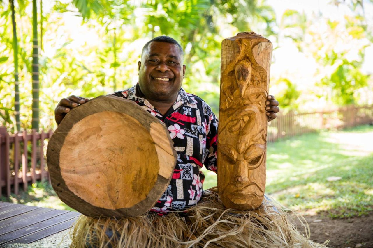 Outrigger Fiji Beach Resort Korotogo Exterior foto A man from the Solomon Islands with a drum and a carved post